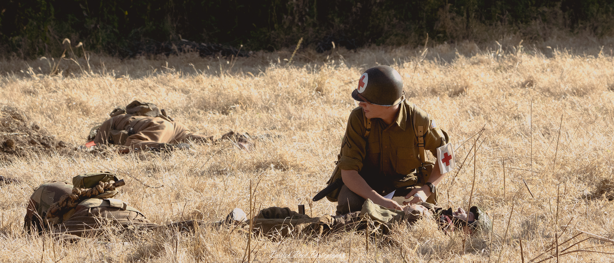 A young medic crouches beside a wounded soldier in a battlefield setting. The medic, dressed in a military uniform with a red cross armband, is focused and determined, applying a field dressing to the soldier’s injury. The wounded soldier lies on the ground, grimacing in pain but relieved to receive assistance. Around them, the chaotic backdrop of the battlefield is evident, with hints of destruction and conflict in the distance. The medic's expression conveys compassion and urgency, highlighting the crucial role of medics during wartime.